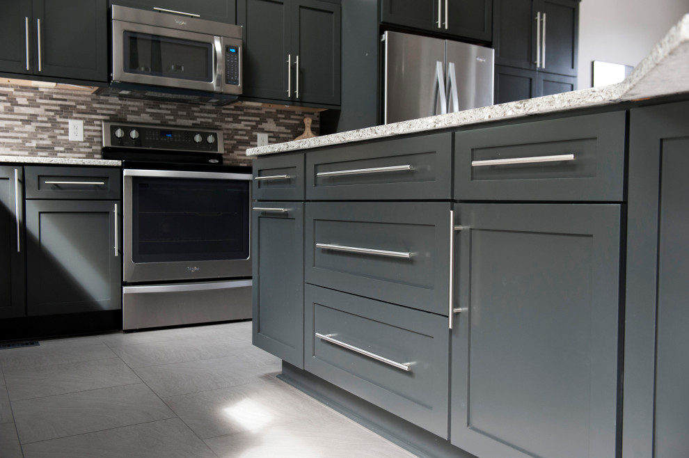 Inspiration for a large modern l-shaped eat-in kitchen in Other with an undermount sink, shaker cabinets, black cabinets, granite benchtops, multi-coloured splashback, mosaic tile splashback, stainless steel appliances, ceramic floors, with island, grey floor and white benchtop.