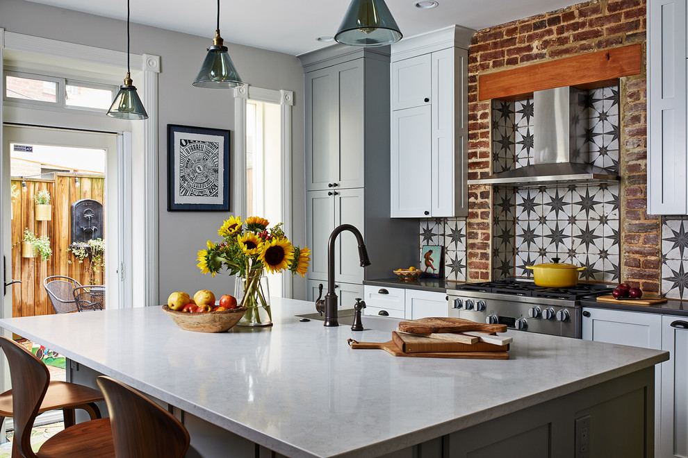 Photo of a mid-sized eclectic single-wall eat-in kitchen in DC Metro with grey cabinets, stainless steel appliances, with island, grey floor and white benchtop.