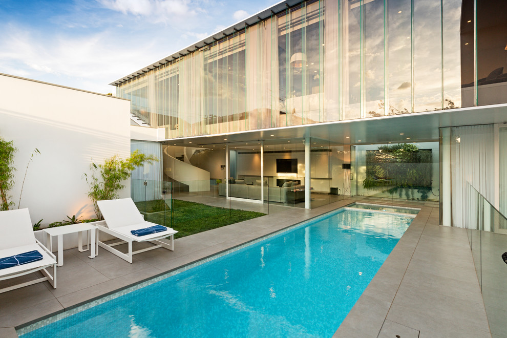 Large contemporary backyard rectangular pool in Melbourne with tile.
