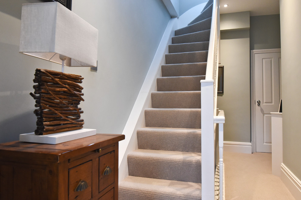 Photo of a mid-sized modern carpeted curved staircase in London with carpet risers.