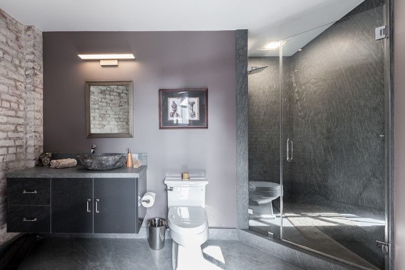 This is an example of a mid-sized modern master bathroom in San Francisco with flat-panel cabinets, grey cabinets, an alcove shower, a two-piece toilet, grey walls, concrete floors, a vessel sink, solid surface benchtops, grey floor and a hinged shower door.