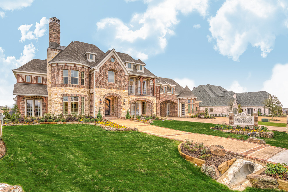Design ideas for a traditional two-storey brick beige exterior in Dallas with a gambrel roof.