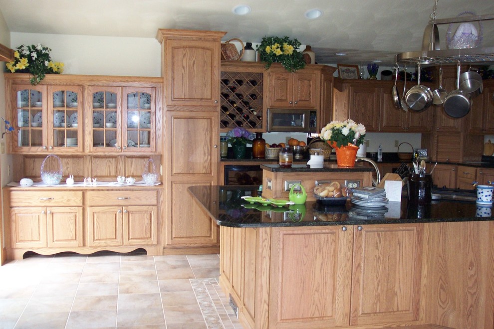 Eat-in kitchen - large l-shaped eat-in kitchen idea with medium tone wood cabinets, beige backsplash, stainless steel appliances and an island