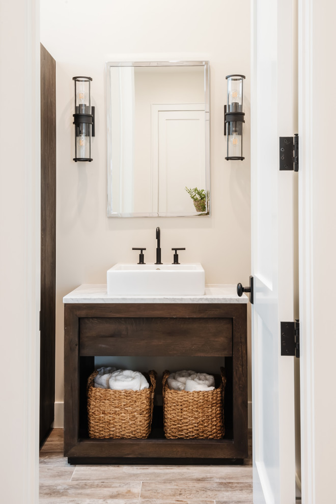 Photo of a small country bathroom in San Diego with freestanding cabinets, medium wood cabinets, an alcove shower, white tiles, beige walls, wood-effect flooring, a vessel sink, marble worktops, beige floors, a hinged door, white worktops, a single sink and a freestanding vanity unit.