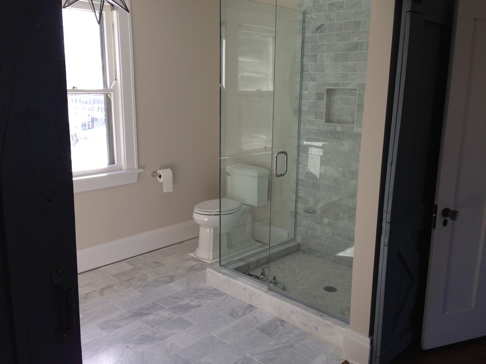 Example of a transitional master white tile and stone tile marble floor corner shower design in Cincinnati with a two-piece toilet and beige walls