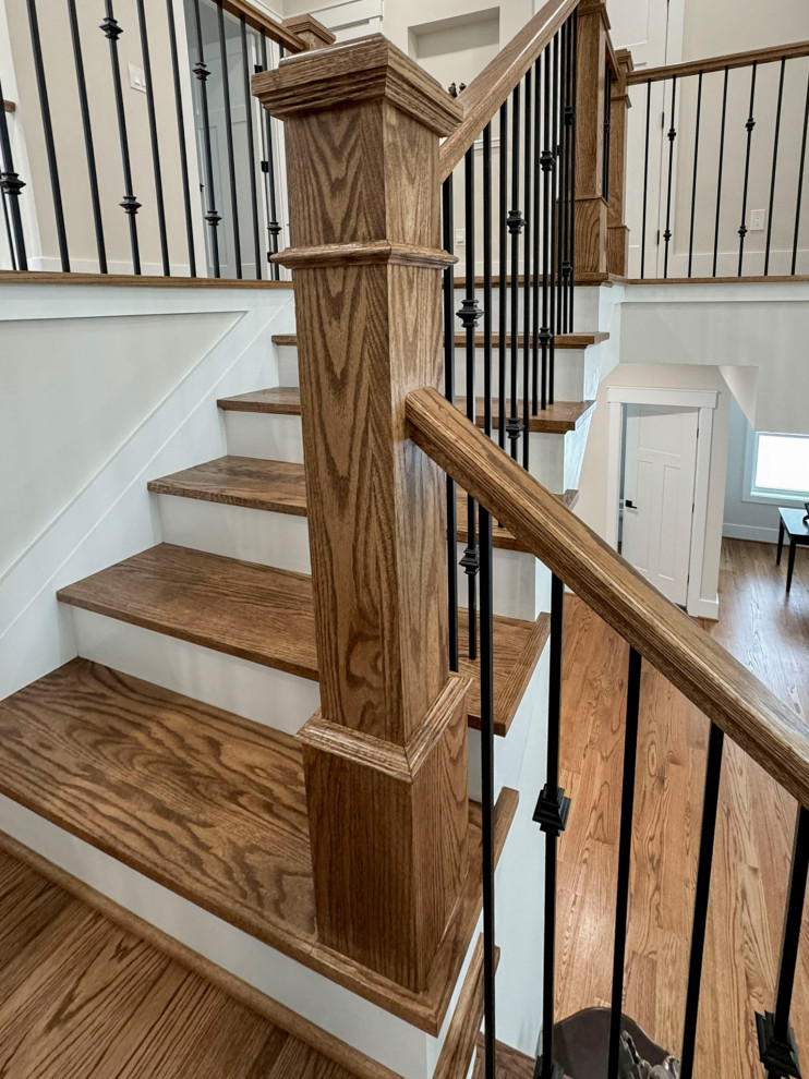 Idée de décoration pour un escalier courbe tradition de taille moyenne avec des marches en bois, des contremarches en bois et un garde-corps en matériaux mixtes.