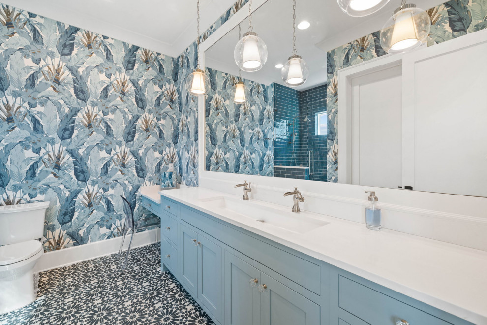 Ejemplo de cuarto de baño único y a medida marinero de tamaño medio con armarios con rebordes decorativos, paredes azules, suelo con mosaicos de baldosas, lavabo de seno grande, suelo azul y papel pintado