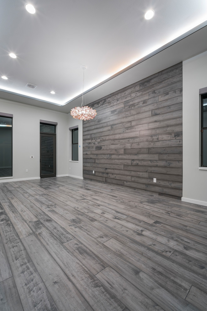 Large contemporary master bedroom in Orlando with grey walls, light hardwood floors and grey floor.
