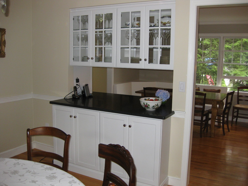 Eat-in kitchen - transitional u-shaped medium tone wood floor eat-in kitchen idea in Boston with an undermount sink, recessed-panel cabinets, white cabinets, gray backsplash, subway tile backsplash, stainless steel appliances, an island and black countertops