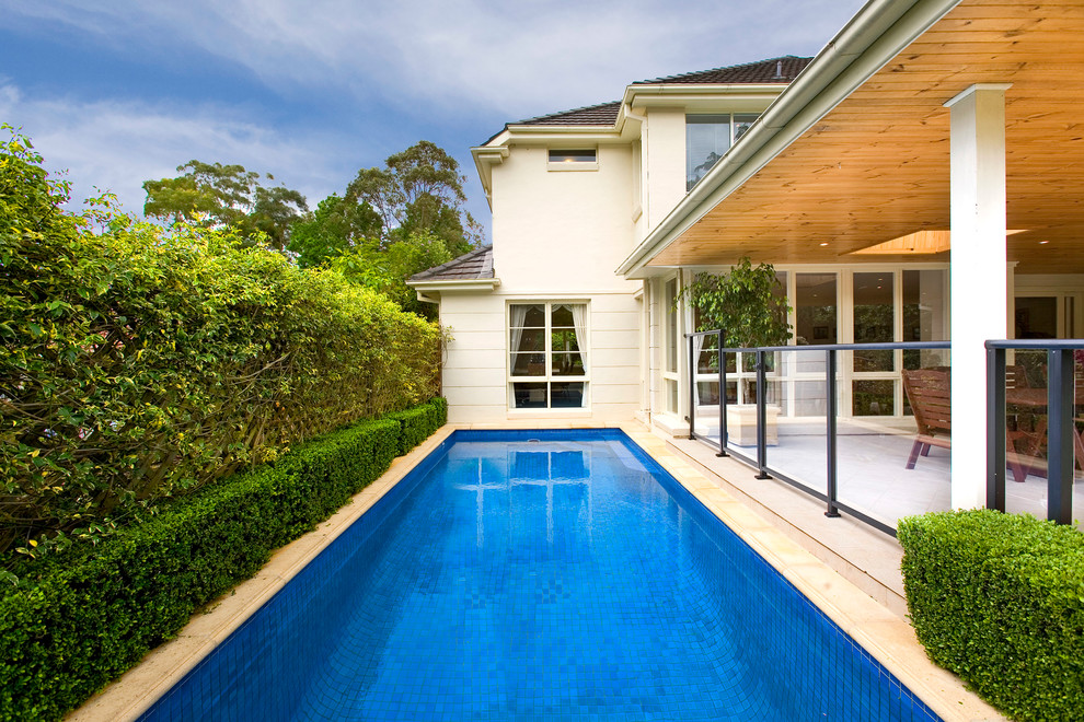 Photo of a mid-sized contemporary side yard rectangular pool in Sydney with natural stone pavers.