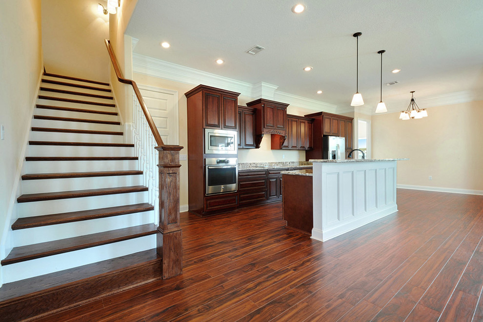 Mid-sized transitional galley medium tone wood floor open concept kitchen photo with an undermount sink, beaded inset cabinets, medium tone wood cabinets, granite countertops, stainless steel appliances and an island