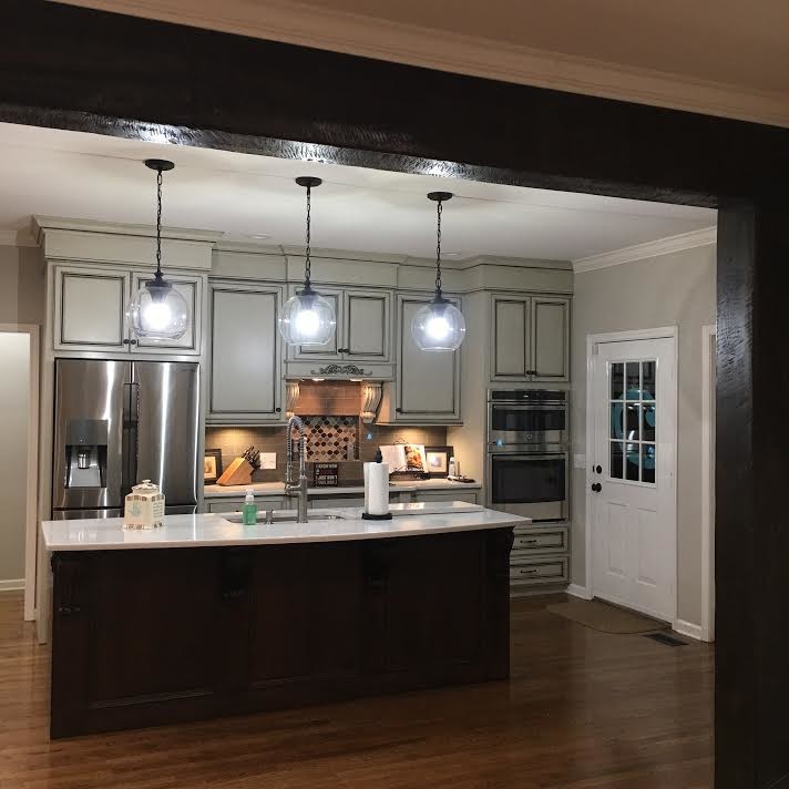 Inspiration for a mid-sized transitional single-wall dark wood floor and brown floor open concept kitchen remodel in Birmingham with an undermount sink, raised-panel cabinets, gray cabinets, gray backsplash, stainless steel appliances and an island