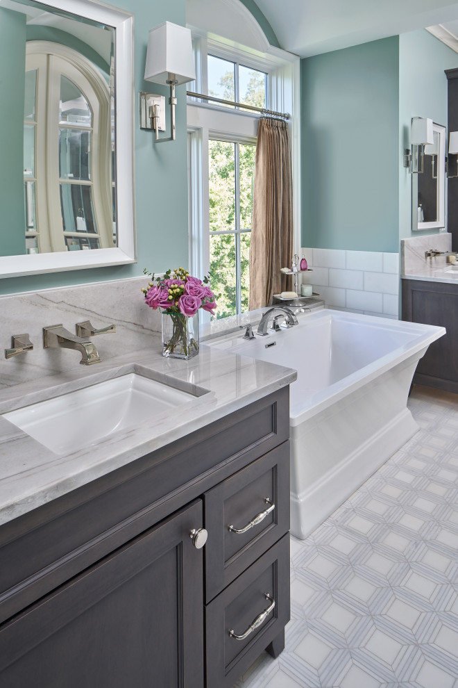This is an example of a mid-sized transitional master bathroom in Charlotte with recessed-panel cabinets, grey cabinets, a freestanding tub, a corner shower, white tile, marble, green walls, mosaic tile floors, an undermount sink, quartzite benchtops, white floor, a hinged shower door, grey benchtops, a double vanity, a freestanding vanity, vaulted and decorative wall panelling.