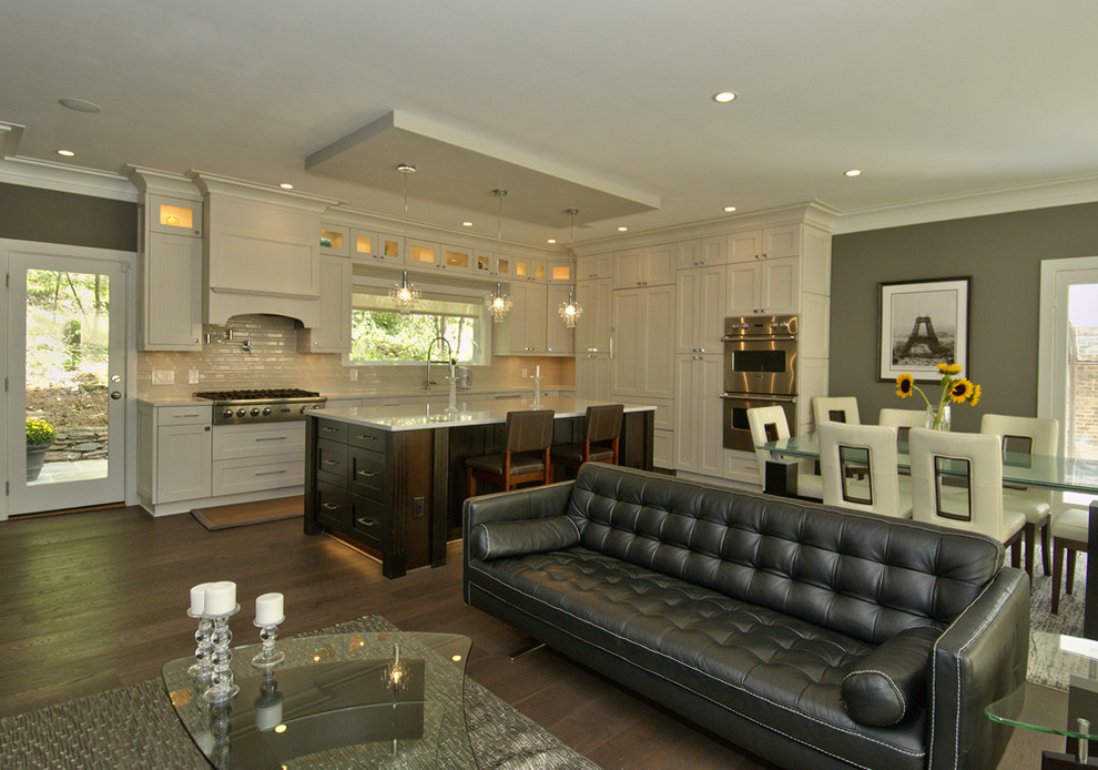 Example of a mid-sized transitional l-shaped dark wood floor open concept kitchen design in DC Metro with an undermount sink, shaker cabinets, white cabinets, quartz countertops, beige backsplash, porcelain backsplash, stainless steel appliances and an island