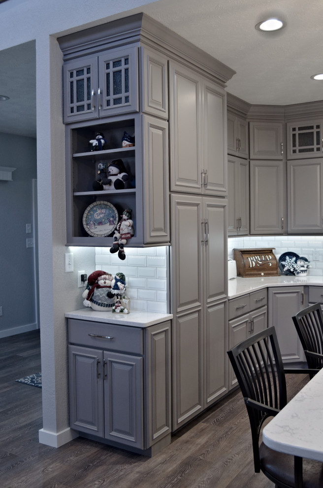 Eat-in kitchen - u-shaped brown floor eat-in kitchen idea with a double-bowl sink, raised-panel cabinets, gray cabinets, marble countertops, white backsplash, stainless steel appliances, an island and white countertops
