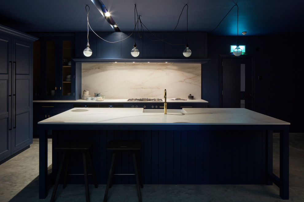 Design ideas for a large contemporary l-shaped eat-in kitchen in London with recessed-panel cabinets, blue cabinets, quartz benchtops, white splashback, stone slab splashback, stainless steel appliances, with island and white benchtop.