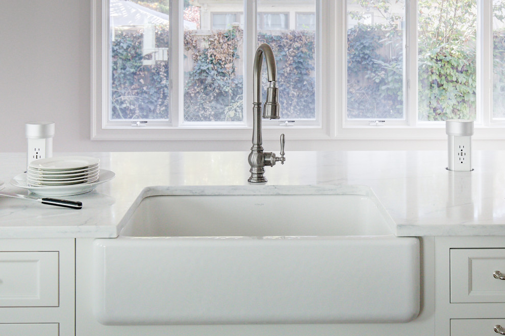 Example of a mid-sized transitional u-shaped medium tone wood floor and brown floor open concept kitchen design with a farmhouse sink, recessed-panel cabinets, white cabinets, quartz countertops, multicolored backsplash, marble backsplash, stainless steel appliances, a peninsula and white countertops