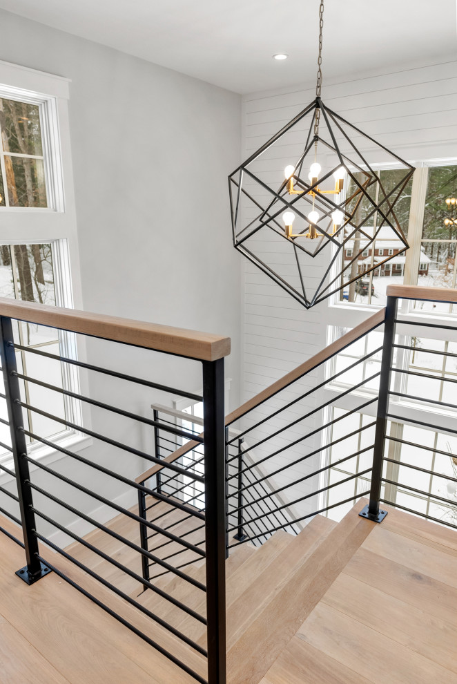 Inspiration for a large country wood u-shaped staircase in Boston with metal railing.