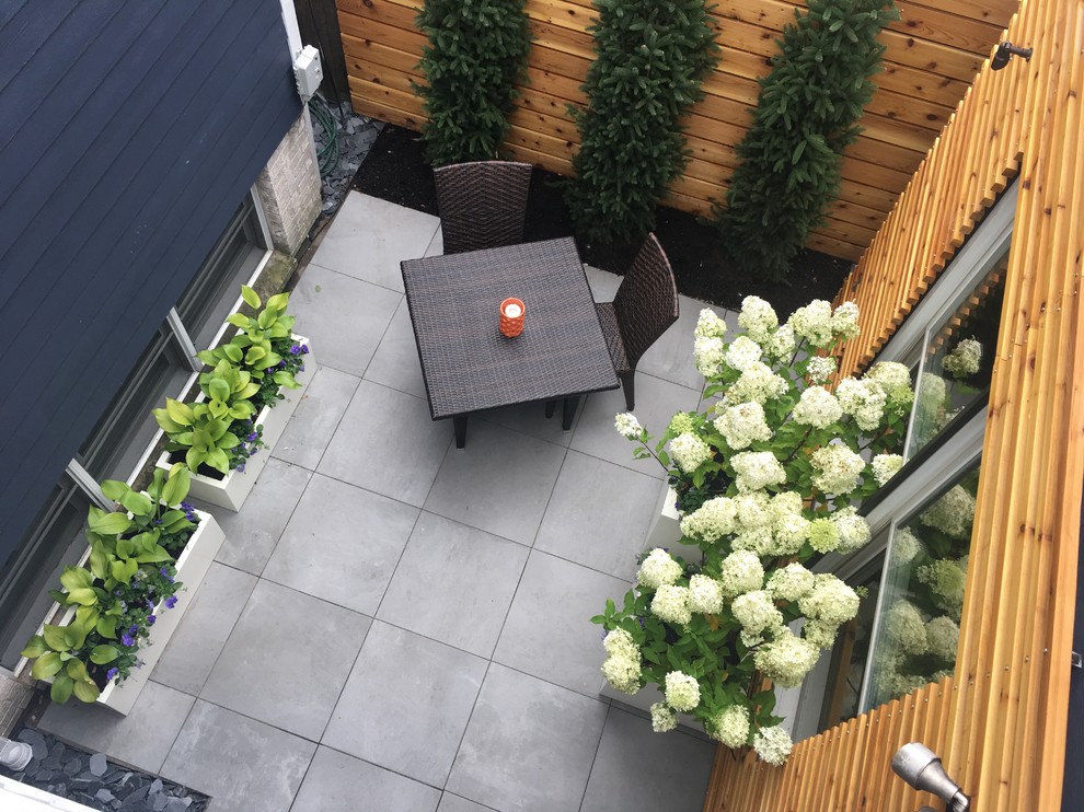 Inspiration for a small contemporary backyard patio in Chicago with tile and no cover.