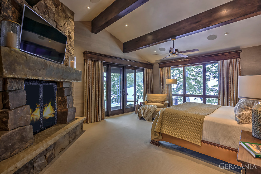 Photo of a country master bedroom in Salt Lake City with beige walls, carpet, a standard fireplace, beige floor, exposed beam and wallpaper.