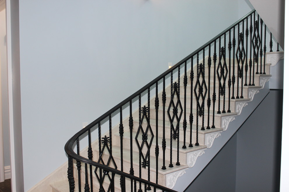Идея дизайна: большая лестница в стиле неоклассика (современная классика) с мраморными ступенями, подступенками из мрамора и металлическими перилами