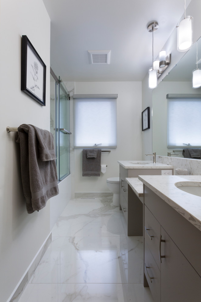 Idéer för mellanstora funkis vitt en-suite badrum, med möbel-liknande, grå skåp, en dusch i en alkov, en toalettstol med hel cisternkåpa, grå kakel, grå väggar, marmorgolv, ett undermonterad handfat, bänkskiva i kvarts, vitt golv och dusch med skjutdörr