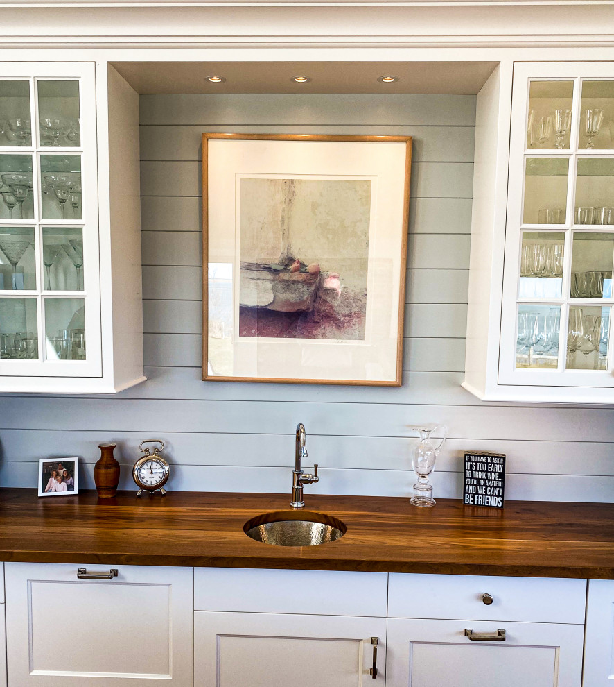 Example of a large transitional open concept medium tone wood floor, brown floor and shiplap wall family room design in Boston with a bar and white walls