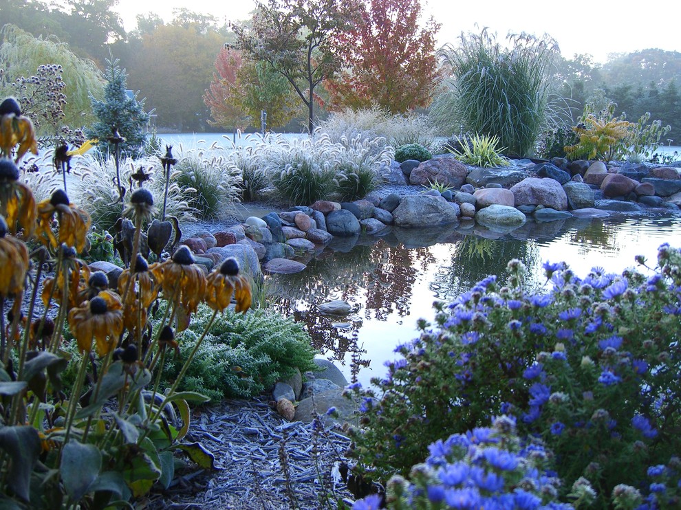 Photo of an expansive traditional backyard partial sun garden in Milwaukee with a water feature.