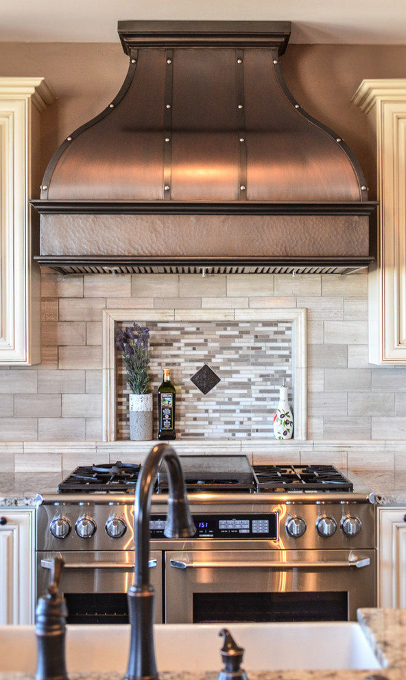 Open concept kitchen - mid-sized transitional l-shaped dark wood floor and brown floor open concept kitchen idea in Denver with a farmhouse sink, raised-panel cabinets, white cabinets, granite countertops, gray backsplash, porcelain backsplash, stainless steel appliances and an island
