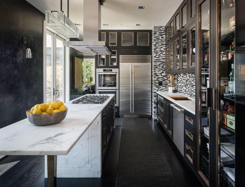 Inspiration for an industrial l-shaped kitchen in Seattle with an undermount sink, marble benchtops, stainless steel appliances, dark hardwood floors, with island, glass-front cabinets, black cabinets, multi-coloured splashback, matchstick tile splashback and black floor.