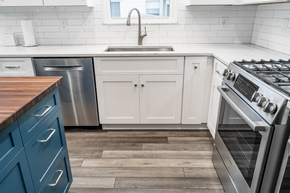 Inspiration for a mid-sized transitional l-shaped eat-in kitchen remodel in Columbus with shaker cabinets, quartz countertops, white backsplash, subway tile backsplash and an island