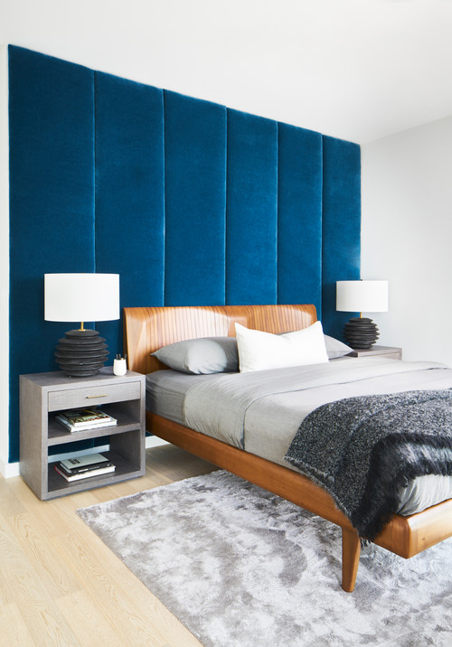 bedroom with grey color scheme and a navy blue accent wall made out of blue wall panels