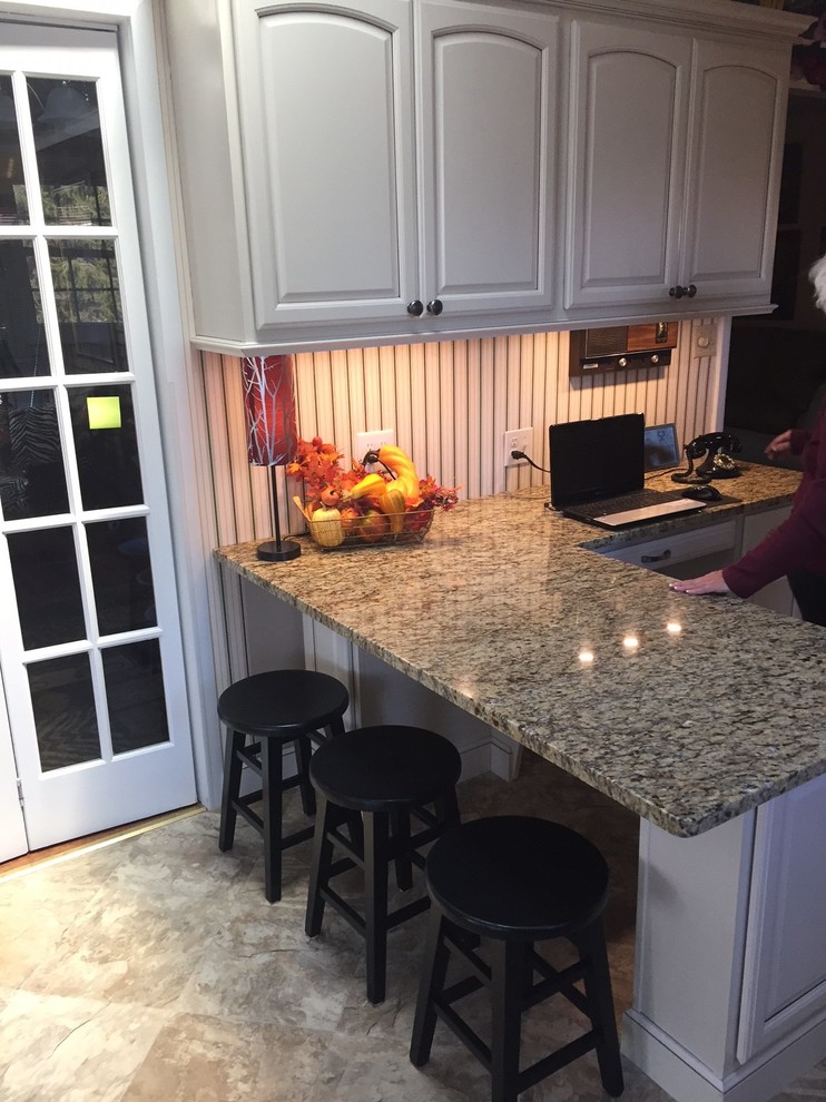 Small transitional l-shaped eat-in kitchen photo with raised-panel cabinets, beige cabinets, granite countertops and a peninsula
