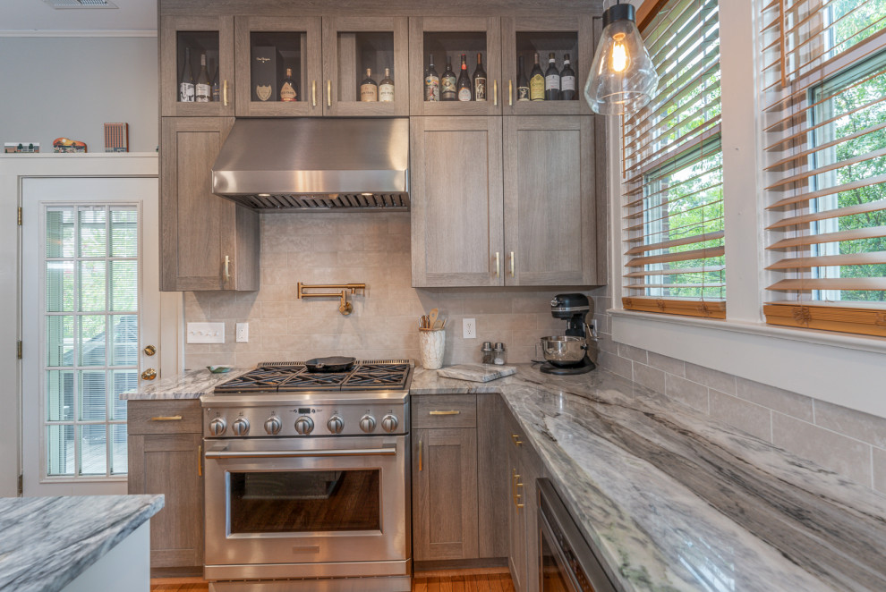 Example of a small transitional u-shaped kitchen design in DC Metro with an undermount sink, shaker cabinets, marble countertops, stainless steel appliances and an island