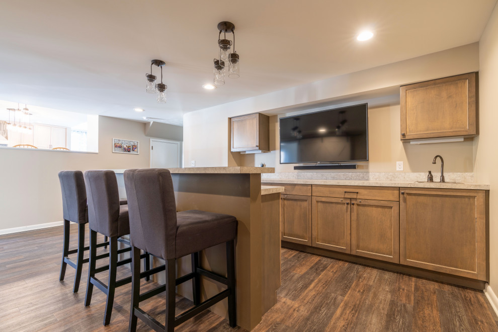 This is an example of a mid-sized contemporary galley seated home bar in Other with a drop-in sink, shaker cabinets, grey cabinets, laminate benchtops, vinyl floors, grey floor and grey benchtop.
