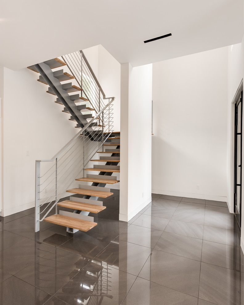 Design ideas for a large modern wood floating staircase in Houston with open risers and cable railing.