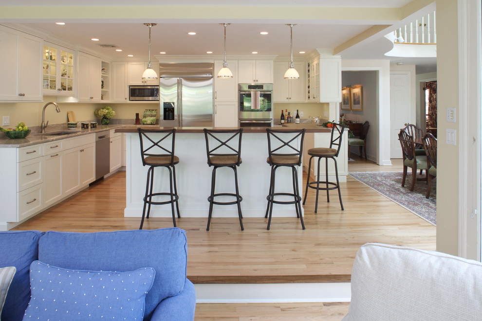 Eat-in kitchen - mid-sized transitional l-shaped light wood floor eat-in kitchen idea in New York with an undermount sink, recessed-panel cabinets, white cabinets, quartzite countertops, stainless steel appliances and an island