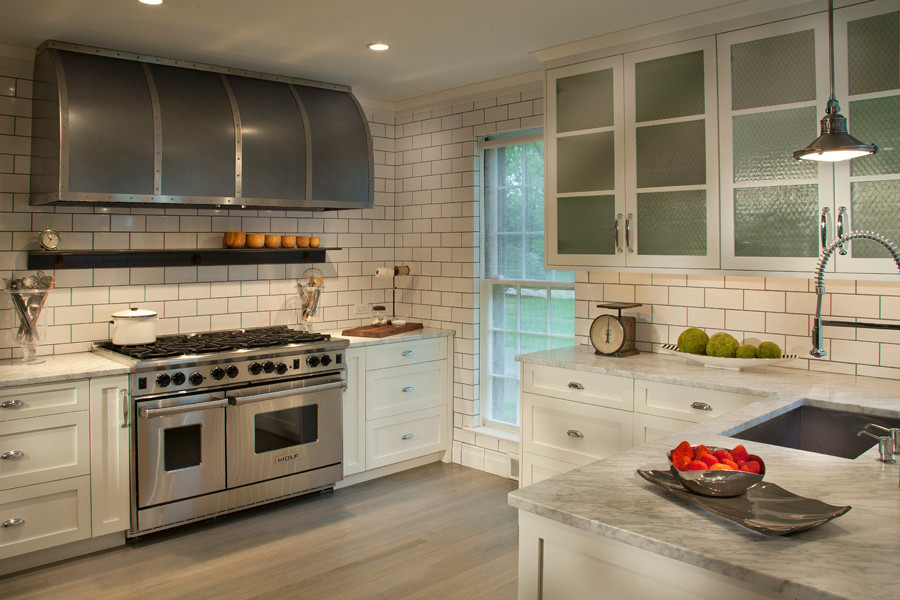 Industrial l-shaped eat-in kitchen in Philadelphia with an undermount sink, white cabinets, white splashback, subway tile splashback, stainless steel appliances and with island.