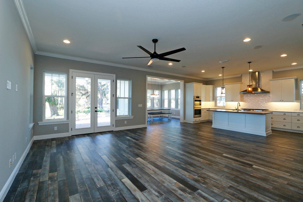 Inspiration for an expansive country open concept family room in Orlando with grey walls, dark hardwood floors and no fireplace.