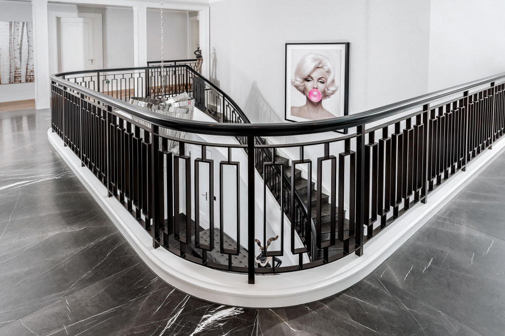 Staircase - large traditional marble curved metal railing staircase idea in Berlin with marble risers
