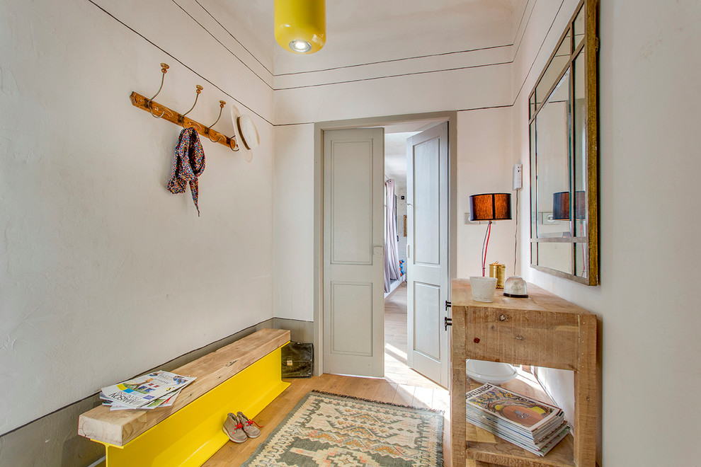 This is an example of a mid-sized eclectic mudroom in Lyon with beige walls and light hardwood floors.