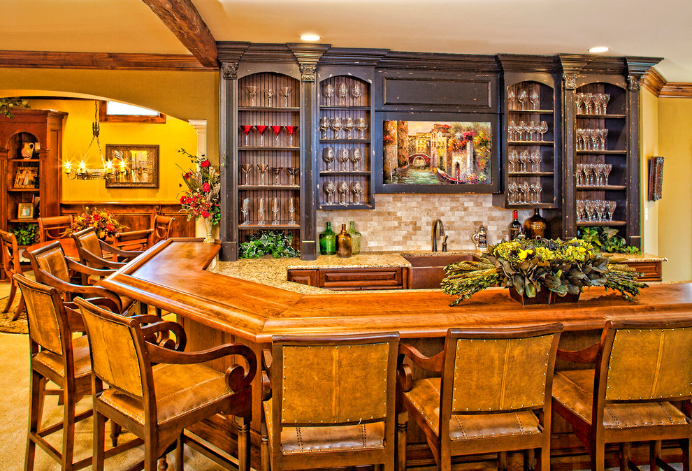 Photo of a traditional u-shaped home bar in Raleigh with carpet, raised-panel cabinets, dark wood cabinets, wood benchtops, beige splashback, mosaic tile splashback and brown benchtop.