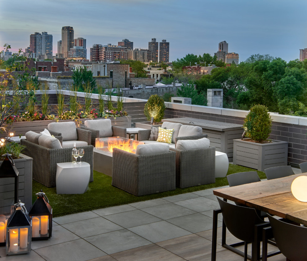 This is an example of an expansive contemporary rooftop deck in Chicago with a fire feature and no cover.