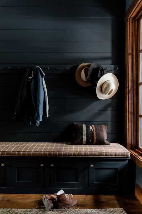 Moody mudroom with Farrow & Ball painted black shiplap walls, built in pegs for coats, and a custom made bench with hidden storage and gold hardware.
Small eclectic medium tone wood floor, brown floor and shiplap wall mudroom photo in Sacramento with black walls 
