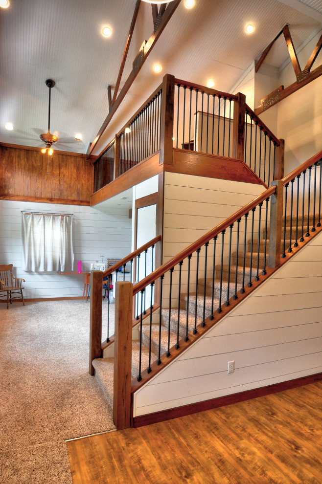 Стильный дизайн: большая п-образная лестница в стиле рустика с ступенями с ковровым покрытием, ковровыми подступенками и перилами из смешанных материалов - последний тренд