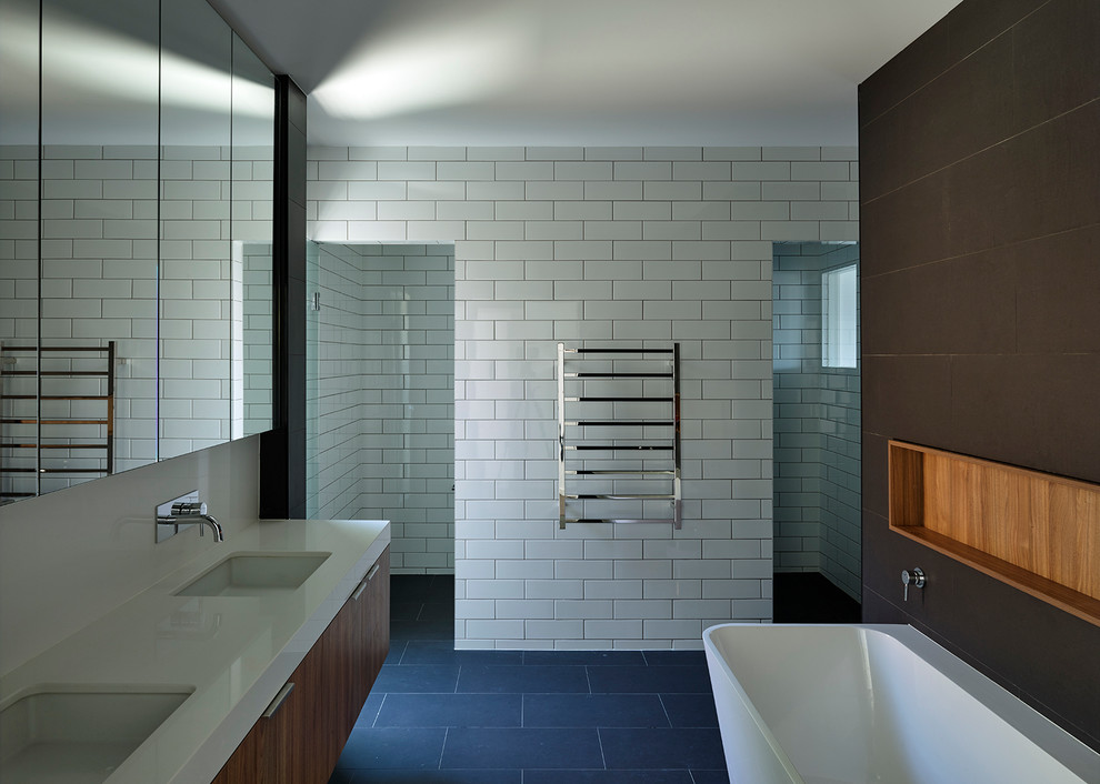 Large contemporary bathroom in Brisbane with a wall-mount sink, medium wood cabinets, granite benchtops, a freestanding tub, an alcove shower, multi-coloured tile and multi-coloured walls.