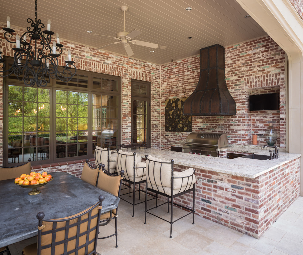 Inspiration for a traditional backyard patio in Houston with natural stone pavers and a roof extension.
