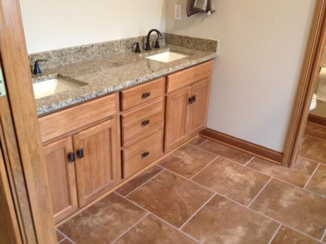 Example of a large master multicolored tile and stone tile ceramic tile corner shower design in Indianapolis with a drop-in sink, medium tone wood cabinets, granite countertops and beige walls