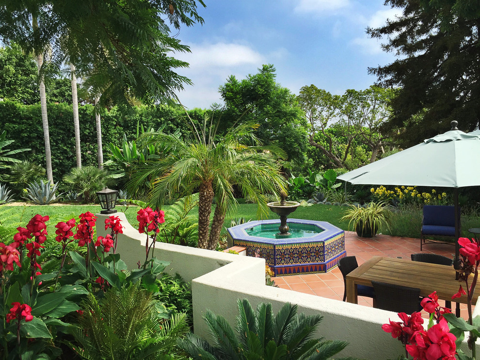 Inspiration for a tropical backyard garden in Los Angeles with a water feature.