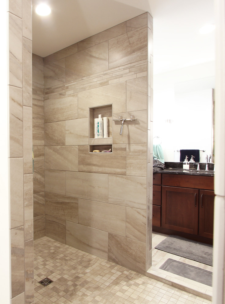 Mid-sized transitional master bathroom in Other with recessed-panel cabinets, dark wood cabinets, an alcove shower, a two-piece toilet, beige tile, limestone, grey walls, limestone floors, an undermount sink, engineered quartz benchtops, multi-coloured floor, an open shower and black benchtops.